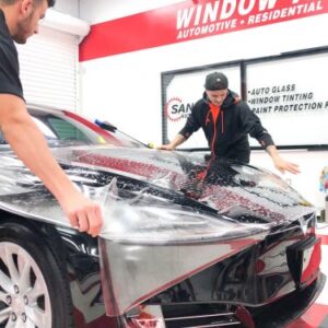 SD Auto Glass and Tint employees applying paint protection film to car